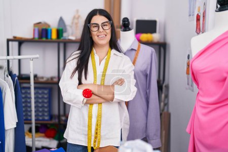 Photo for Young beautiful hispanic woman tailor smiling confident standing with arms crossed gesture at atelier - Royalty Free Image