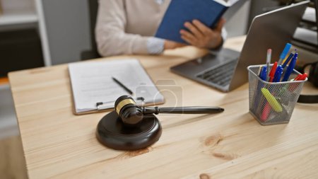 Téléchargez les photos : Femme mûre avocate travaille à l'intérieur au bureau avec ordinateur portable, marteau et documents juridiques sur un bureau en bois. - en image libre de droit