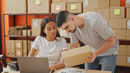 Photo for Man and woman working together, two office workers reading package information on laptop in the warehouse - Royalty Free Image