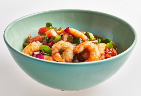 Téléchargez les photos : Une succulente salade de crevettes dans un bol turquoise mettant en valeur des légumes et fruits de mer frais sur fond blanc. - en image libre de droit