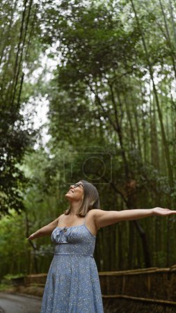 Photo for Joyful hispanic woman embraces freedom in kyoto's bamboo forest, smiling, posing with open arms, looking around. beautiful, confident, carefree latin adult in glasses enjoying japan's green beauty. - Royalty Free Image