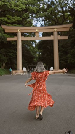 Photo for Joyful hispanic woman smiling with open arms, looking around at meiji temple, showcasing confidence and happiness - Royalty Free Image