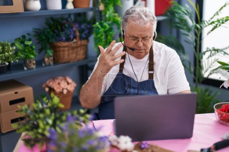 Photo for Middle age grey-haired man florist having video call at florist - Royalty Free Image