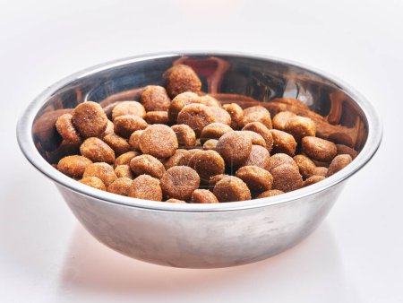 Photo for Delicious bowl of dog food balls over isolated white background - Royalty Free Image