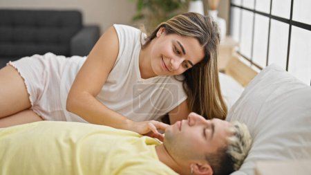 Téléchargez les photos : Beau couple allongé sur le lit regardant petit ami pendant le sommeil dans la chambre - en image libre de droit