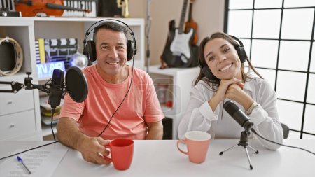Téléchargez les photos : Intervieweurs hommes et femmes partageant un moment café dans un studio de radio - en image libre de droit