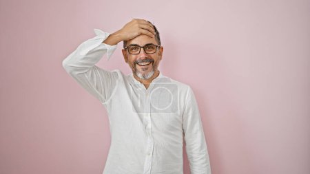 Foto de Joven hombre hispano de pelo gris de pie con expresión sorpresa sobre un fondo rosa aislado - Imagen libre de derechos