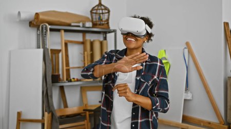 Photo for African american woman in vr headset interacting playfully in a creative workshop studio - Royalty Free Image