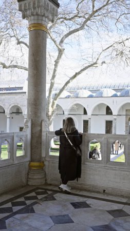 Photo for A woman gazes across the historical courtyard of topkapi palace in istanbul, conveying a sense of turkish heritage and travel. - Royalty Free Image