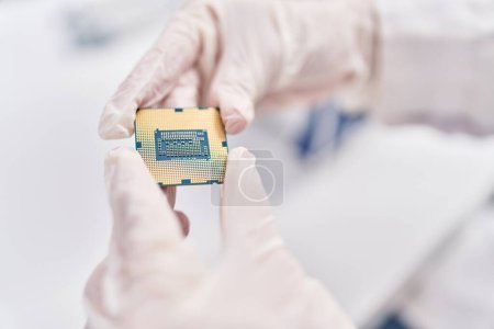 Foto de Joven mujer rubia científica sosteniendo chip procesador de CPU en el laboratorio - Imagen libre de derechos