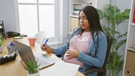 Schwangere junge Frau Chefin macht sich Notizen bei Geschäftsabwicklung über Videoanruf im Büro
