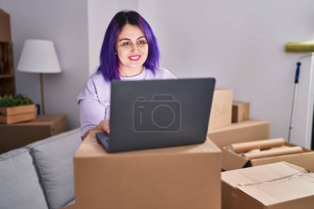 Photo for Young beautiful plus size woman smiling confident using laptop at new home - Royalty Free Image
