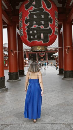 Belle femme hispanique à lunettes capturée s'éloignant, révélant une vue arrière au majestueux sanctuaire senso-ji, tokyo