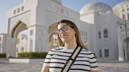 A young woman smiles serenely during her visit to the majestic qasr al watan in abu dhabi.