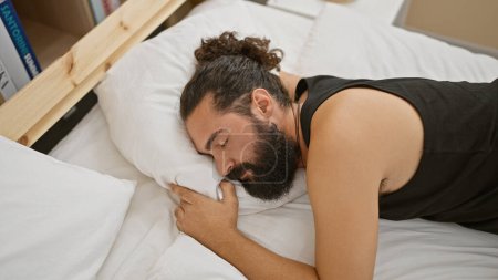 Foto de Hombre barbudo guapo que duerme tranquilamente en un ambiente acogedor dormitorio, que representa un momento de tranquilidad y descanso. - Imagen libre de derechos
