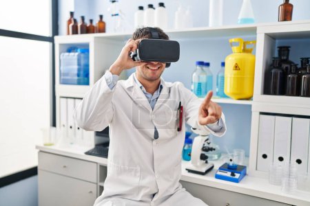 Photo for Young hispanic man scientist using virtual reality glasses at laboratory - Royalty Free Image