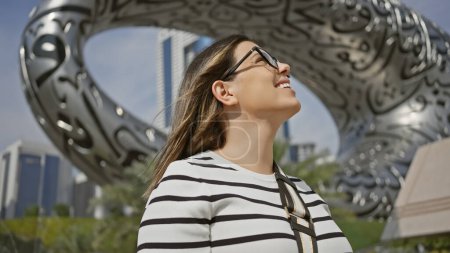 Happy adult woman enjoying modern architecture in sunny dubai cityscape