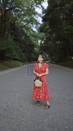 Téléchargez les photos : Belle jeune femme hispanique portant des lunettes debout souriant regardant autour du temple meiji - en image libre de droit