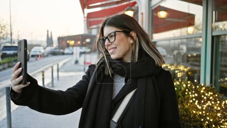 Téléchargez les photos : Une jeune femme prend un selfie dans une rue animée d'Istanbul, mettant en valeur les voyages urbains et le tourisme urbain. - en image libre de droit