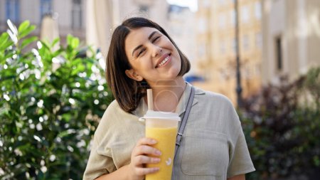 Téléchargez les photos : Jeune belle femme hispanique buvant du thé bulle dans les rues de Vienne - en image libre de droit