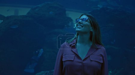 Téléchargez les photos : Une jeune femme souriante fait l'expérience des merveilles marines dans un aquarium de dubai. - en image libre de droit