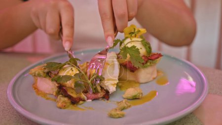 Eine Person, die ein Gourmet-Menü in einem rosafarbenen Restaurant genießt, das raffinierten Geschmack und elegante kulinarische Erfahrung widerspiegelt.