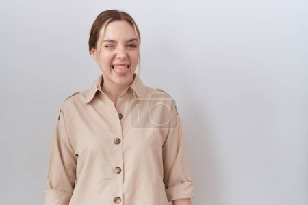 Téléchargez les photos : Jeune femme caucasienne portant une chemise décontractée collant la langue heureuse avec une expression drôle. concept d'émotion. - en image libre de droit