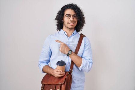 Photo for Hispanic man with curly hair drinking a cup of take away coffee pointing aside worried and nervous with forefinger, concerned and surprised expression - Royalty Free Image