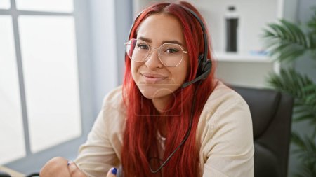 Téléchargez les photos : Charme irlandais au travail, joyeuse rousse femme maîtrisant l'art du soutien en ligne, répandant la joie au bureau avec casque - en image libre de droit
