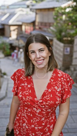 Photo for Smiling with joy, a beautiful hispanic woman confidently posing on gion's old kyoto streets - a perfect casual portrait of a successful female having fun - Royalty Free Image