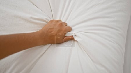 Photo for Close-up of a hand clutching white bed sheets tightly - Royalty Free Image