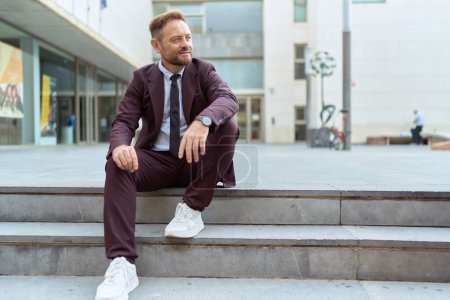 Téléchargez les photos : Homme d'âge moyen homme d'affaires travailleur souriant confiant assis sur les escaliers à la rue - en image libre de droit
