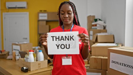 Foto de Mujer afroamericana fuerte y dedicada voluntaria en el centro de caridad, señalando con resolución; un retrato del servicio comunitario en acción - Imagen libre de derechos