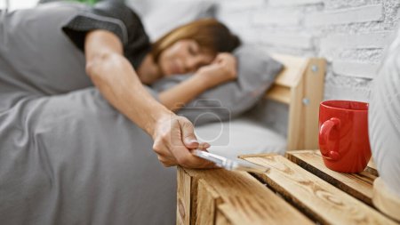 Téléchargez les photos : Somnolent jeune femme hispanique magnifiquement relaxant au lit, confortablement couché en pyjama confortable, regardant l'heure sur smartphone dans la chambre, repos matinal intérieur avec réveil - en image libre de droit