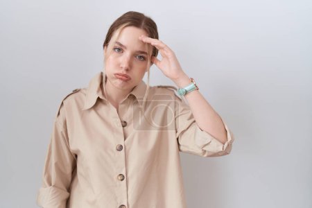 Foto de Mujer caucásica joven con camisa casual preocupada y estresada por un problema con la mano en la frente, nerviosa y ansiosa por la crisis - Imagen libre de derechos