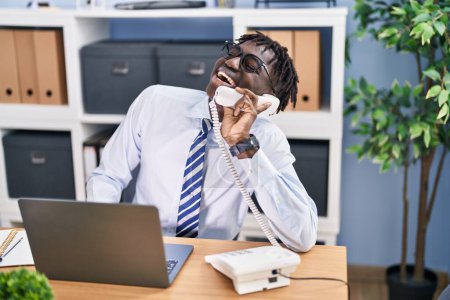 Photo for African american man business worker talking on telephone using laptop at office - Royalty Free Image