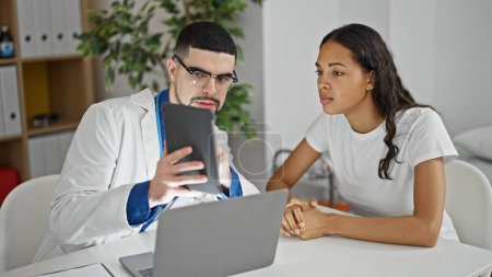 Foto de Conversación táctil en el interior, el médico y el paciente hablan en la clínica durante una consulta seria - Imagen libre de derechos