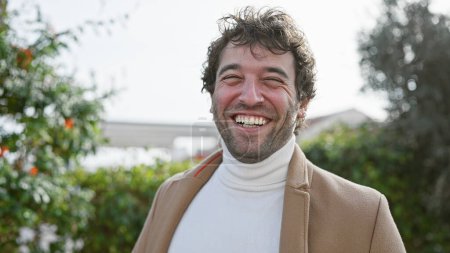 Foto de Hombre hispano sonriente en estilo casual al aire libre con fondo verde - Imagen libre de derechos