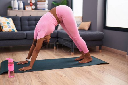 Téléchargez les photos : Femme afro-américaine formation yoga à la maison - en image libre de droit