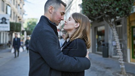 Ein verliebtes Paar umarmt sich auf einer belebten städtischen Straße und ruft inmitten des städtischen Trubels Gefühle der Romantik hervor.