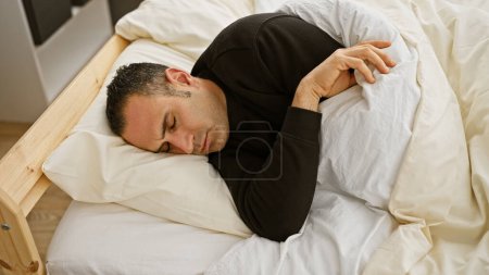 Foto de Hombre hispano durmiendo pacíficamente en un ambiente cómodo dormitorio, lo que implica descanso y relajación. - Imagen libre de derechos