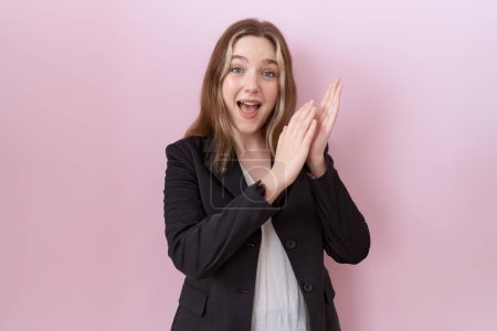 Téléchargez les photos : Jeune femme d'affaires caucasienne portant une veste noire applaudissant et applaudissant heureux et joyeux, souriant mains fiers ensemble - en image libre de droit