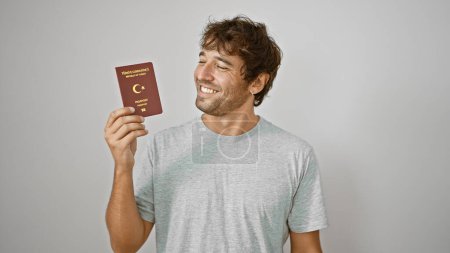Photo for Turk youngster beaming with joy, holding his passport to turkey, isolated on a white background - Royalty Free Image