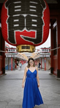 Schöne hispanische Frau mit Brille, fröhlichem Lächeln im Senso-ji-Tempel, eingetaucht in japanische Tradition, fröhlicher lateinischer Erwachsener, der die reiche Kultur Tokyos erkundet