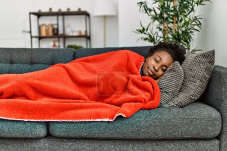 African american woman lying on sofa sleeping at home