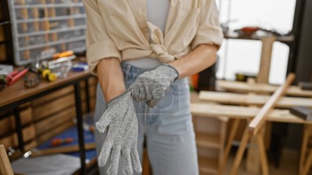 Hände mit Handschuhen, die Welt der Frauen in der Tischlerei und Holzbearbeitung, einem Beruf des Schrotts, in einer Innenwerkstatt