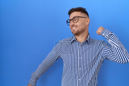 Téléchargez les photos : Homme hispanique avec barbe portant des lunettes dansant heureux et joyeux, souriant décontracté et confiant écoutant de la musique - en image libre de droit