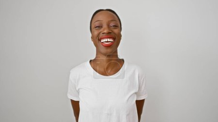 Selbstbewusste afrikanisch-amerikanische Frau, die freudig lächelt und vor einem isolierten weißen Hintergrund steht.