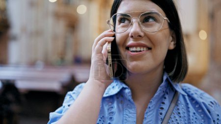 Téléchargez les photos : Jeune belle femme hispanique visitant l'église parlant au téléphone à l'église Saint-Karl Borromus - en image libre de droit