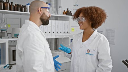 Two scientists standing together speaking at laboratory